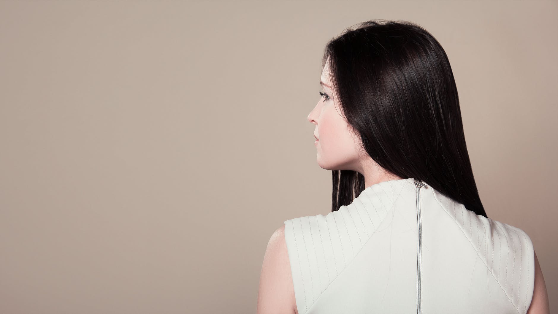 woman in white sleeveless high neck top showing her back
